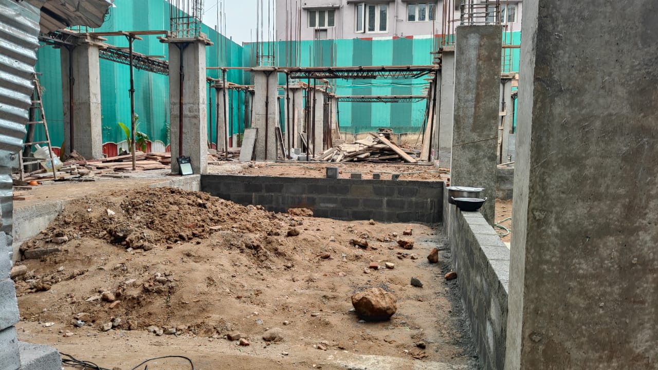 Active civil construction site with concrete columns and masonry work