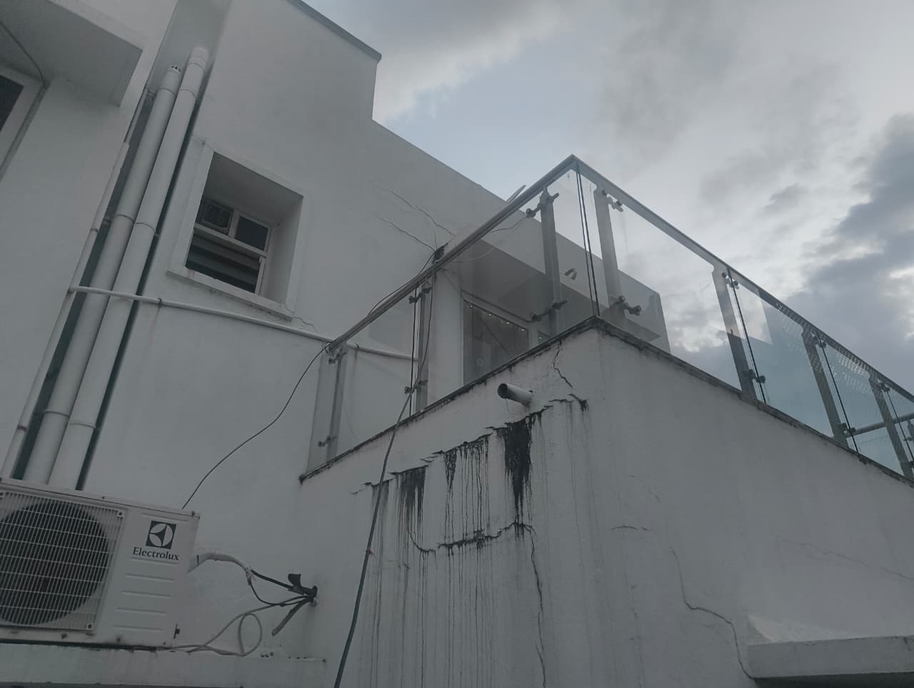 Exterior wall with visible cracks and water staining before repair