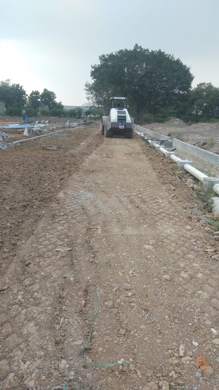 Road roller preparing an internal road at a plot development site