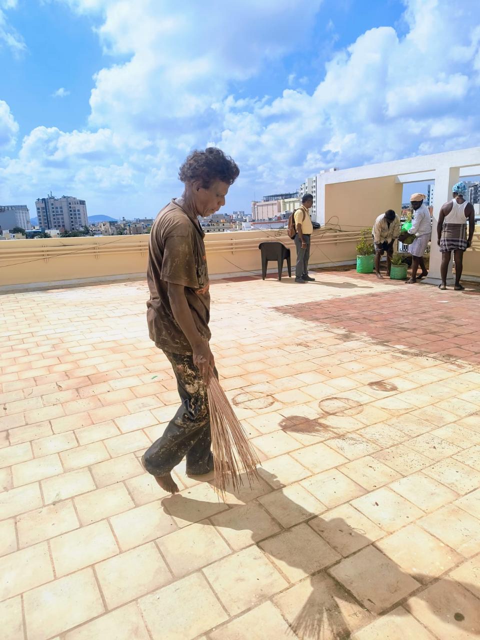 Worker cleaning a tiled terrace during waterproofing preparation